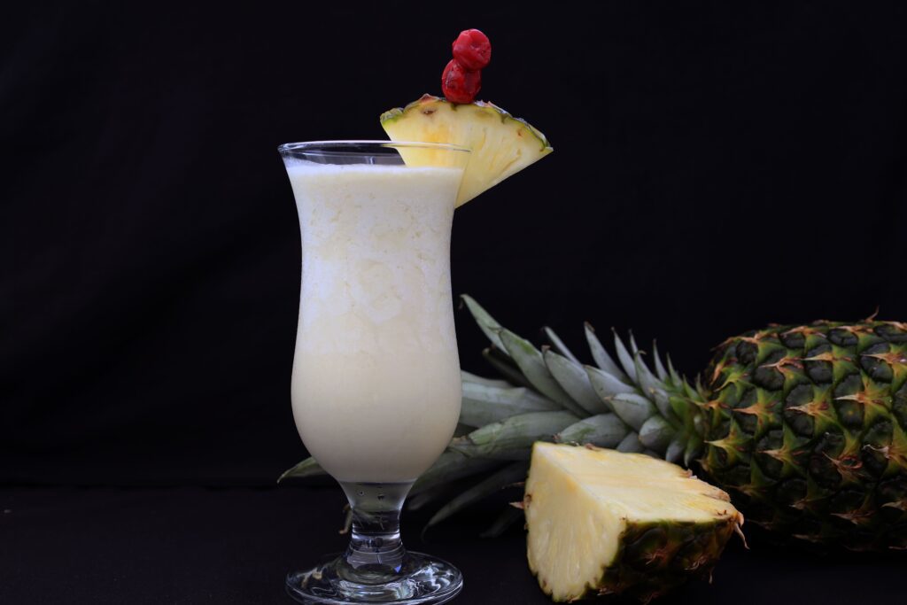 A refreshing pina colada garnished with fresh pineapple slices, ideal for tropical settings.